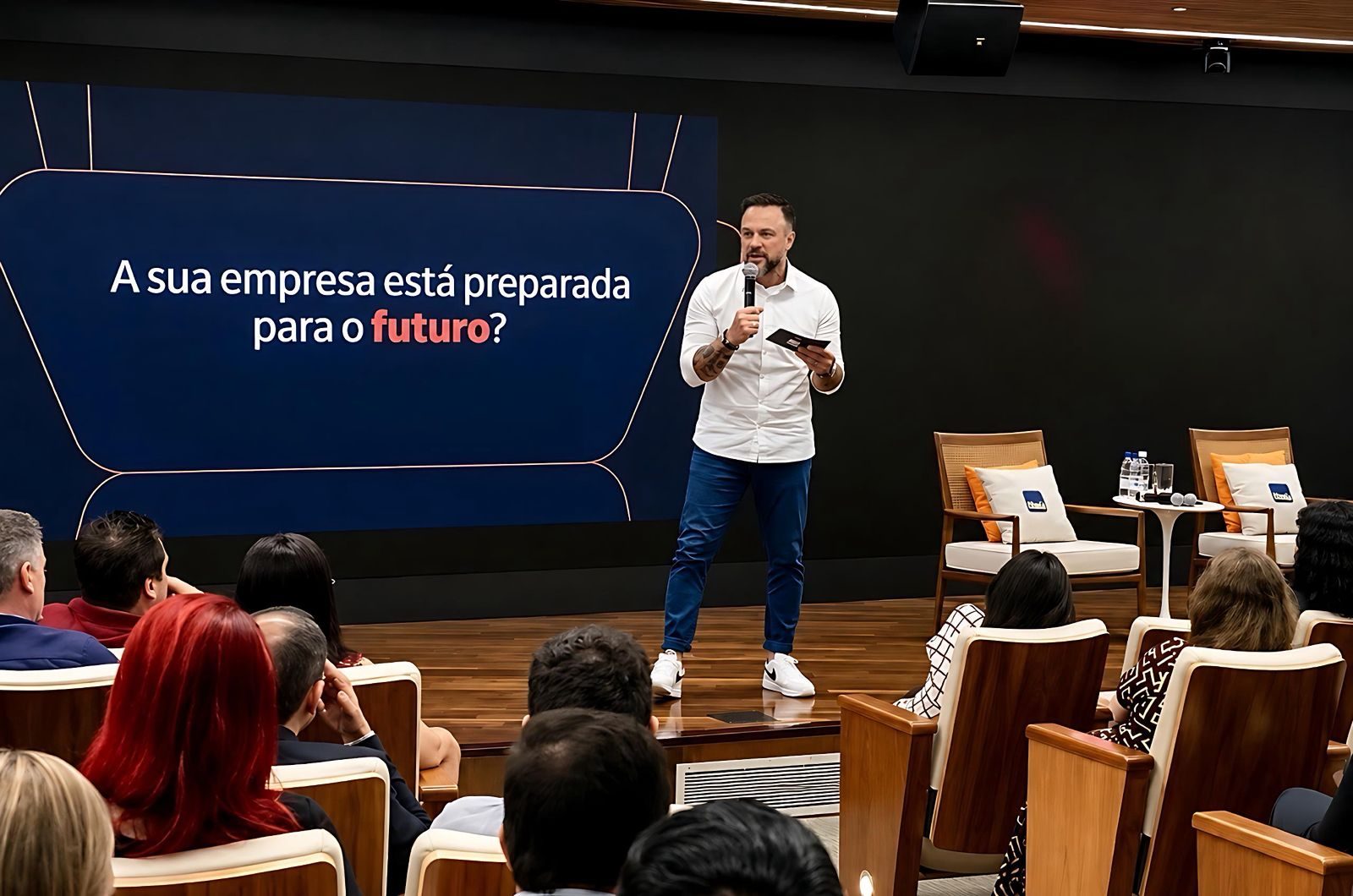 Valter Pinheiro conduzindo uma palestra em auditório corporativo lotado, ao lado do telão com a pergunta “A sua empresa está preparada para o futuro?”